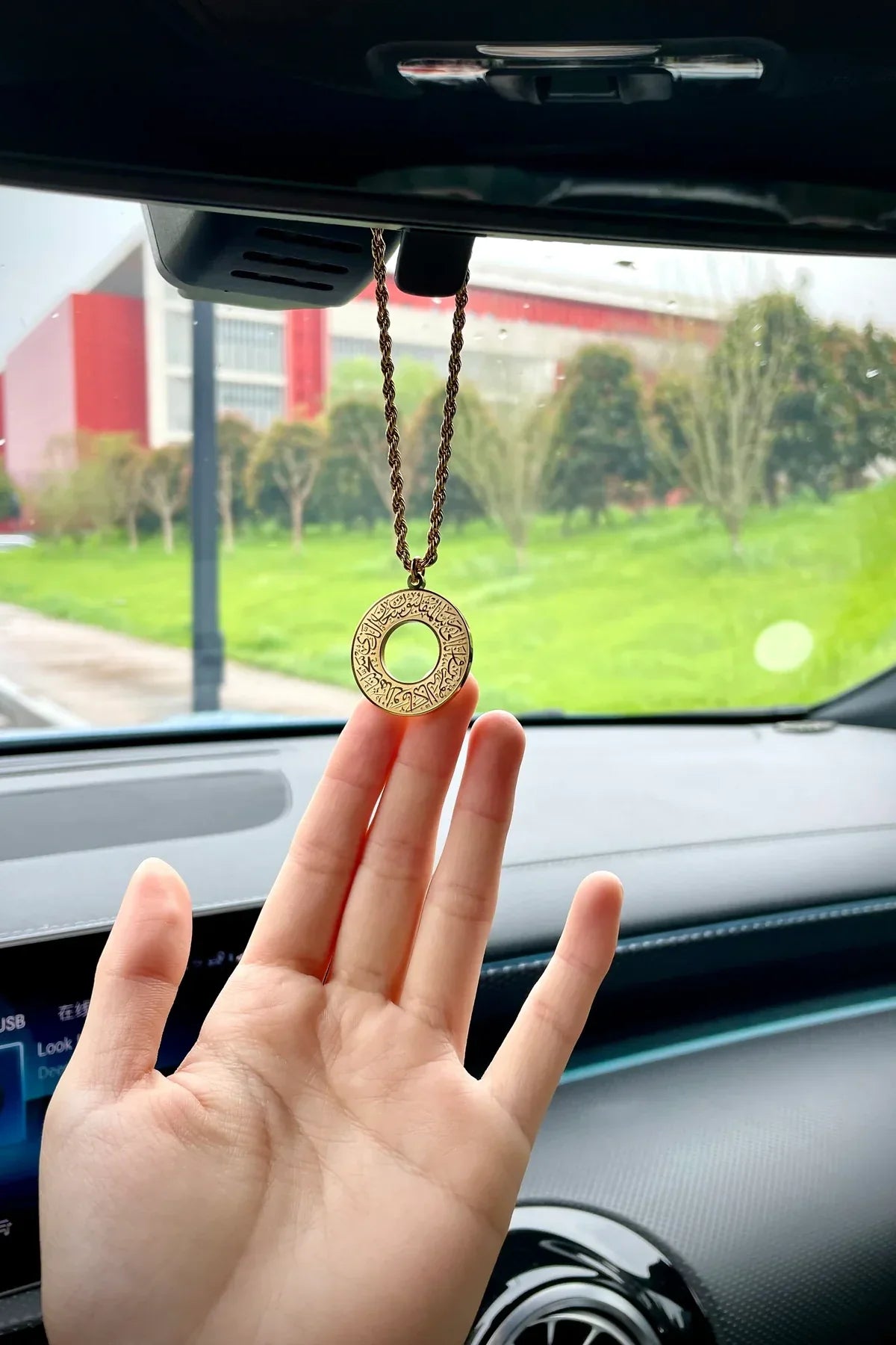 Urbian Burj DUA-Al-SAFAR round car hanger attached to a vehicle seat headrest for hanging accessories or personal items.