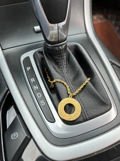 Urbian Burj DUA-Al-SAFAR round car hanger hanging from a vehicle's headrest with a sleek round design and adjustable strap.